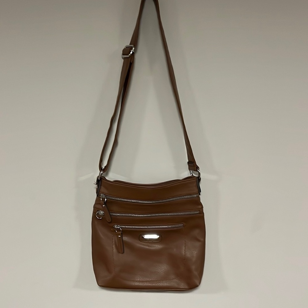 Tyler Rodan, tan bag with multiple zippers and pockets